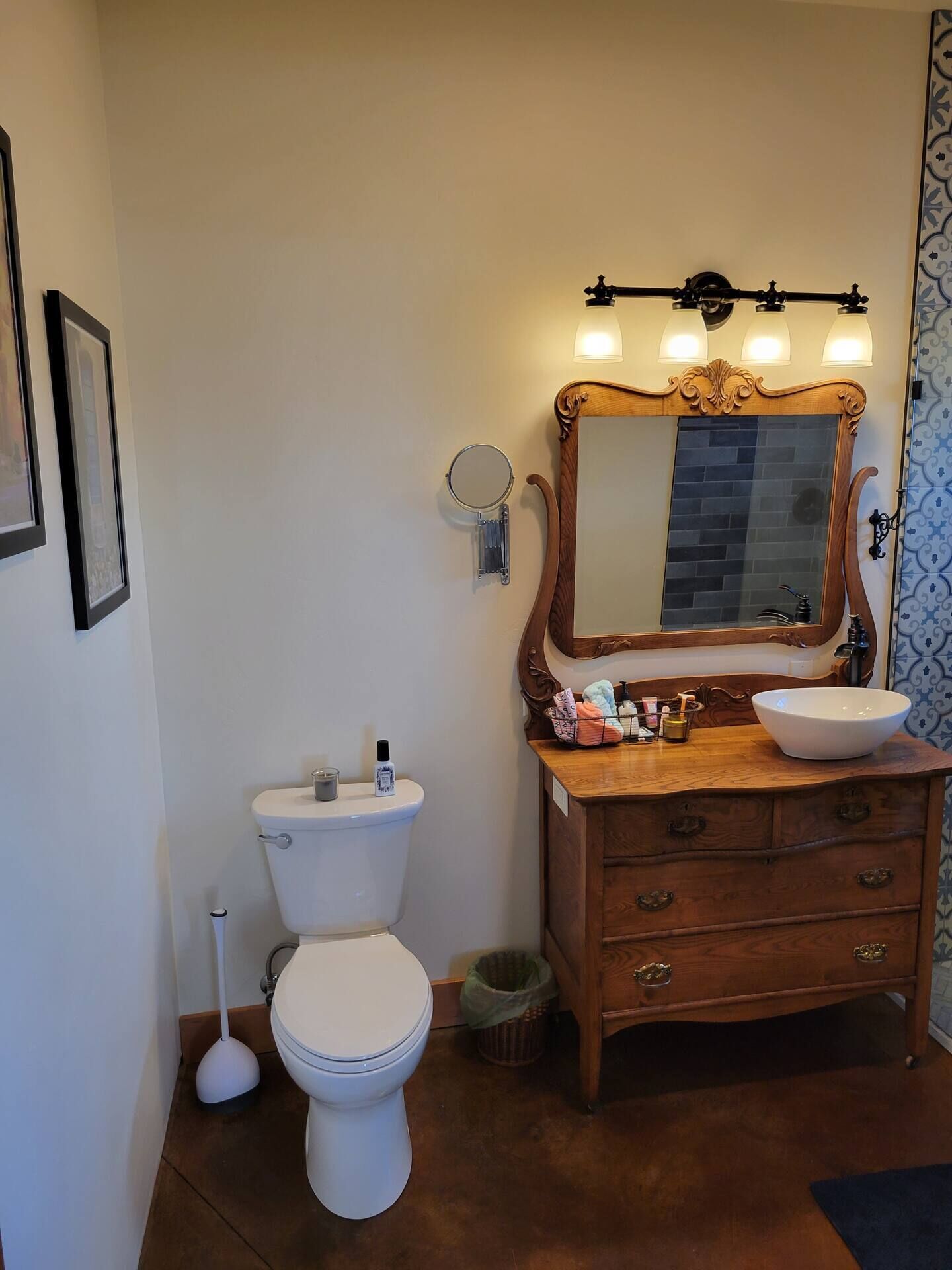 A bathroom with a wooden vanity, a large mirror, a white toilet, and a bidet.