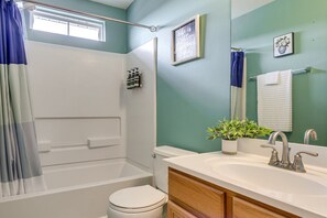 Een badkamer met een bad, toilet en wastafel.