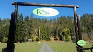 A wooden archway with a sign for 'Reflections Inn' and a 'No Solicitations' sign.