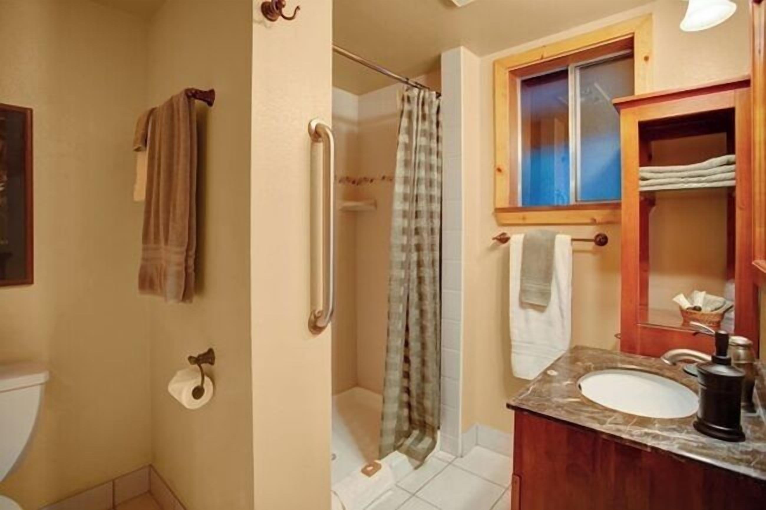 A bathroom with a shower, toilet, and sink.