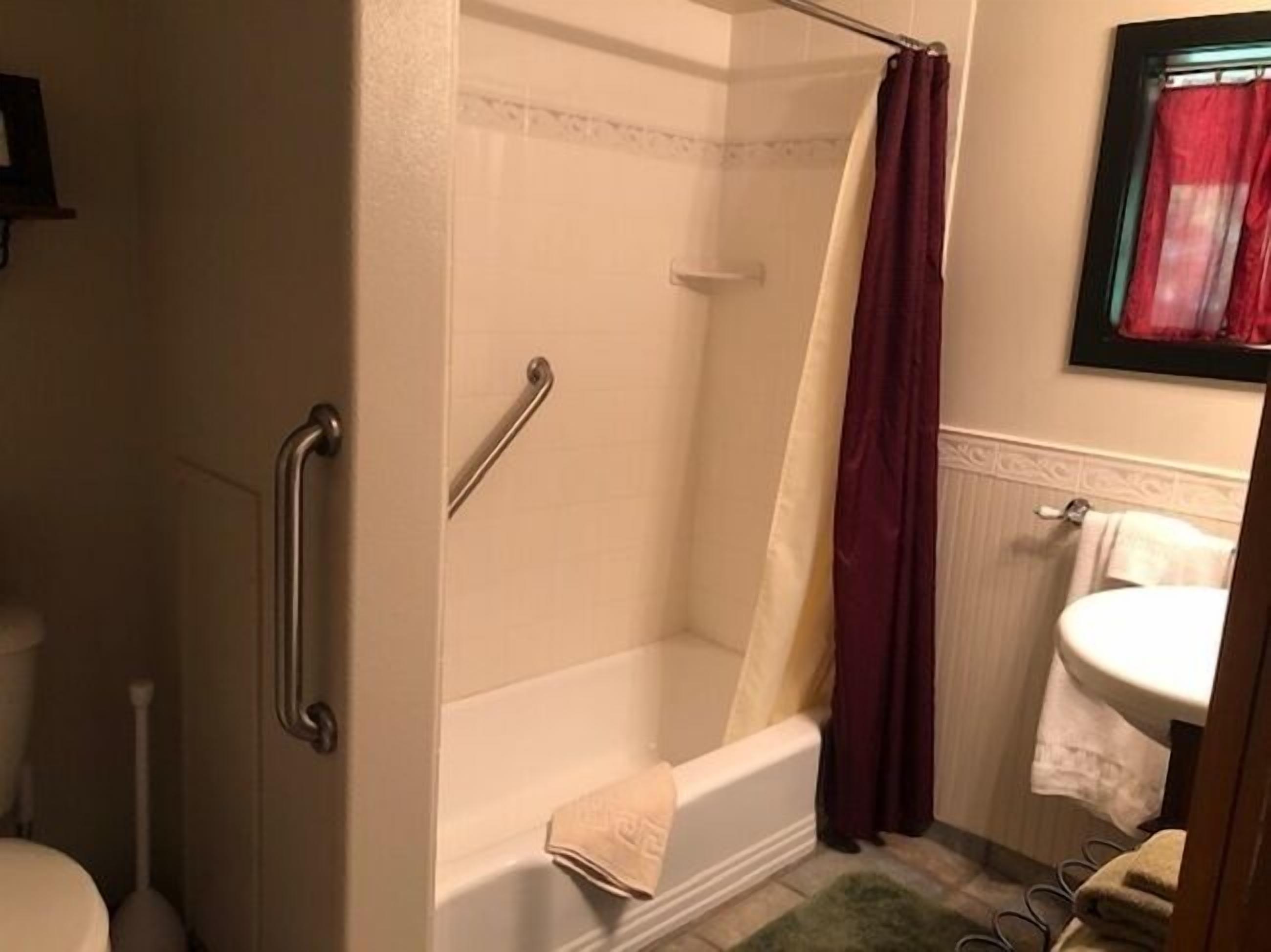 Un baño con bañera, ducha, inodoro y lavamanos.