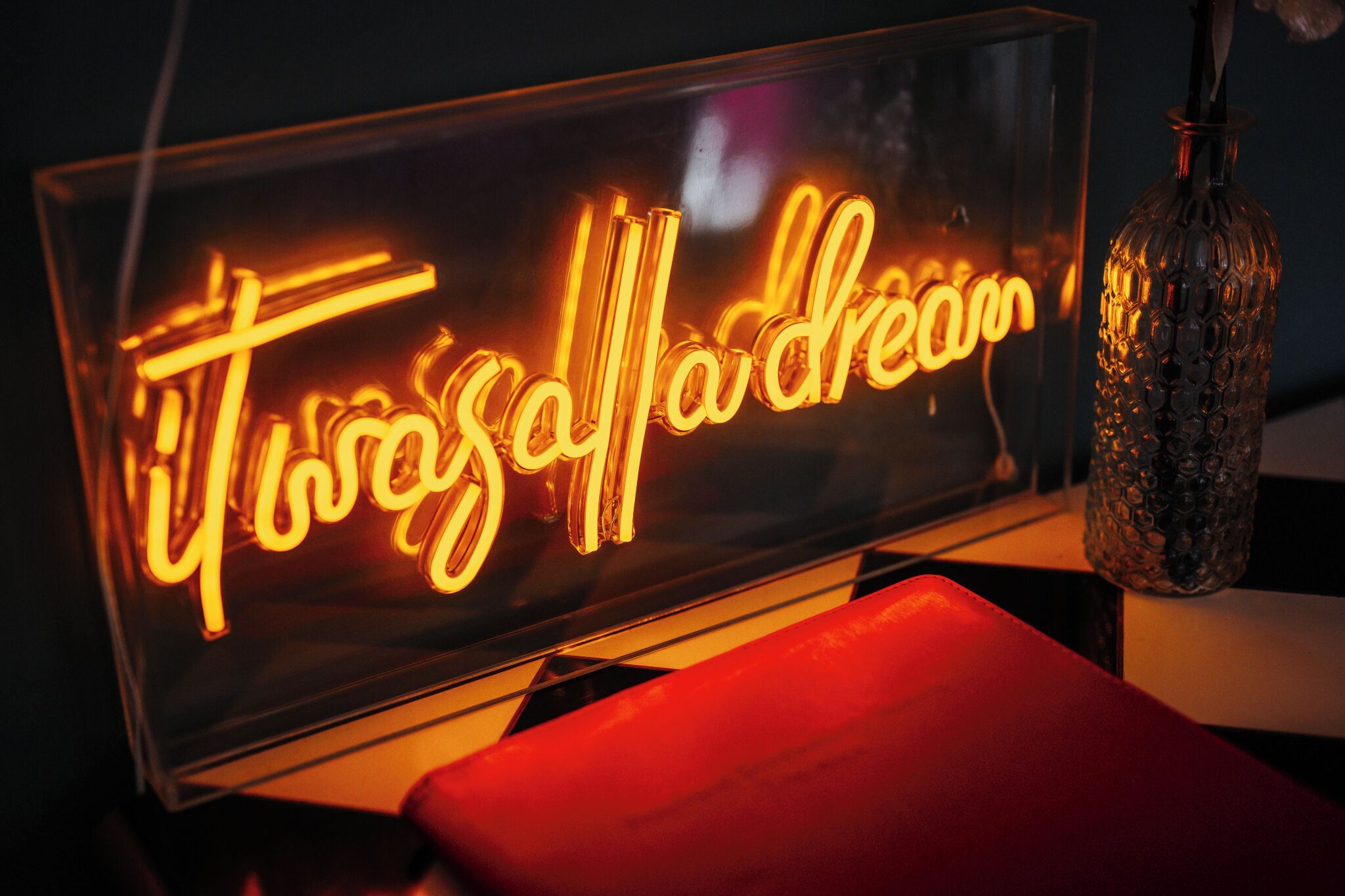 A neon sign with the text "Tuscaloaner dream" in a glass case.