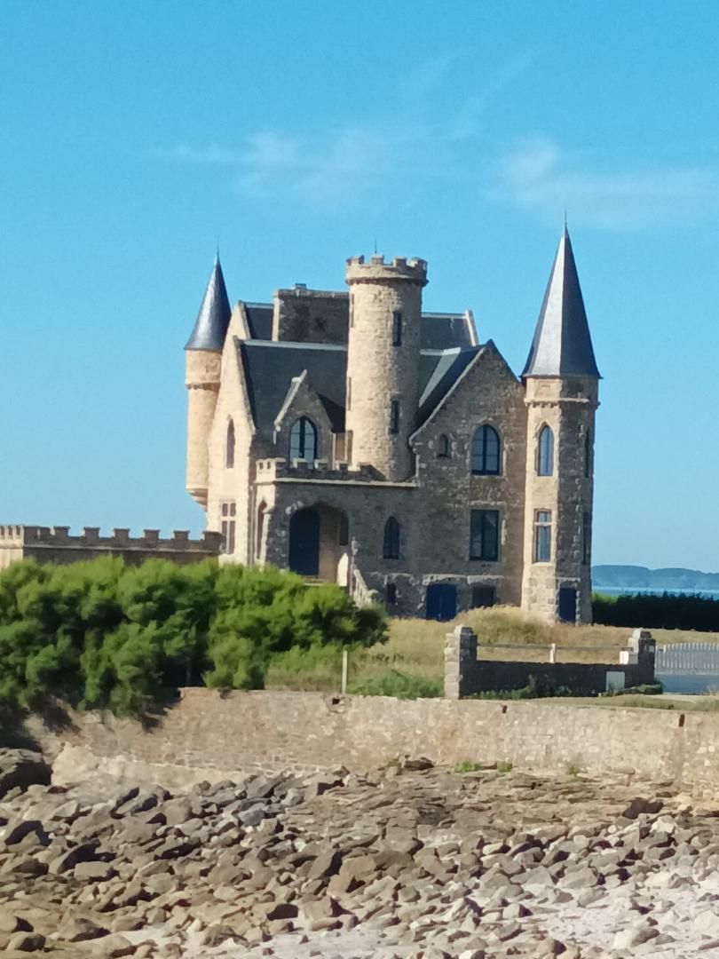 A large, historic stone castle with multiple towers and a central courtyard.