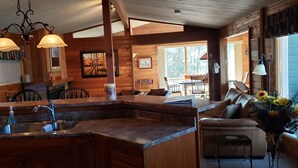 A cozy cabin interior with a kitchen, dining area, and living room.