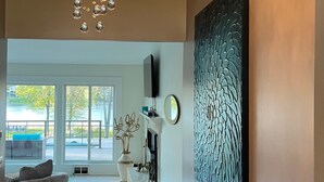 Un interior moderno con un amplio ventanal, una chimenea y un panel decorativo en la pared.