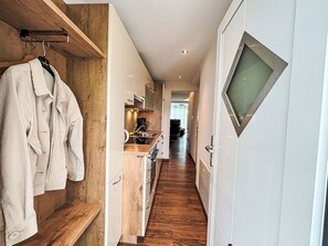 Een koelkast, een oven, een vaatwasser, kookgerei, borden en bestek