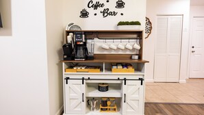 Ein Kaffee-Arrangement mit Kaffeemaschine, Tassen und Kaffeefiltern auf einem Holzboden.