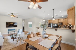 A spacious living room with a dining area, kitchen, and a ceiling fan. - Peaceful Mountain Views: 5 Acres + 6 min to Old Town, 15 min to Wineries (Temecula)