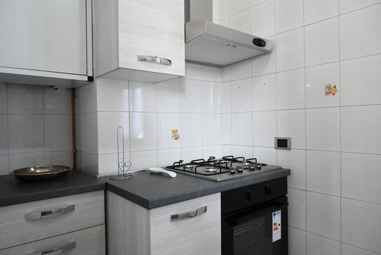 Een koelkast, een oven, eettafels