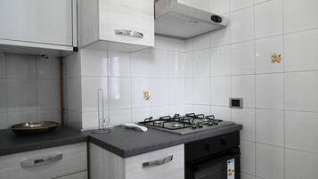 Een koelkast, een oven, eettafels