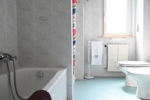 A bathroom with a bathtub, toilet, and a towel rack. - P061 – Porto Recanati, spacious and comfortable four-room apartment (Porto Recanati)