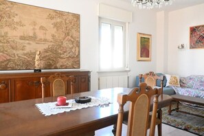 A dining area with a table, chairs, a painting, and a window. - P061 – Porto Recanati, spacious and comfortable four-room apartment (Porto Recanati)