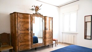 A room with a bed, a wooden wardrobe, a chair, and a window. - P061 – Porto Recanati, spacious and comfortable four-room apartment (Porto Recanati)