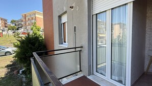 A balcony with a metal railing, a sliding glass door, and a small window. - S350 - Sirolo, comfortable three-room apartment in the center (Sirolo)