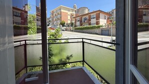 A residential area with apartment buildings, a street, and a balcony with a mesh railing. - S350 - Sirolo, comfortable three-room apartment in the center (Sirolo)