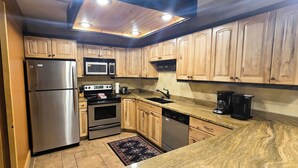 A kitchen with wooden cabinets, stainless steel appliances, and a built-in microwave. - 2BR/2BA Park Station #143 on Main St @ Town Lift, Pool & Hot Tubs, Free Parking (Park City)