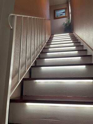 Un escalier dont les rampes et les marches sont éclairées.