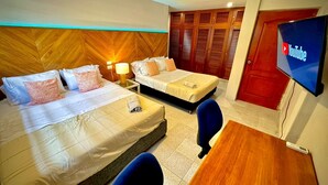 A hotel room with two beds, a desk, a TV, and a wardrobe. - Gallery Beach Home Jacuzzi Jacuzzi Hockey & Billiards (Cartagena de Indias)