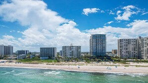 A coastal cityscape with high-rise buildings, a sandy beach, and clear blue skies. - Charming 1-bedroom condo in delightful Pompano Beach with WiFi, AC (Pompano Beach)