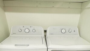 A laundry room with two white front-loading washing machines.