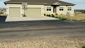 A two-story house with a garage, a driveway, and a small front yard.