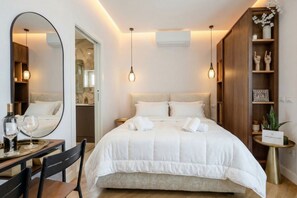 A modern hotel room with a large bed, a round mirror, a small dining table, and a side table with a plant. - Skyline Mirjana – Cozy Apartment with Terrace (Bari)