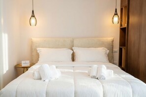 A double bed with white linens, two bedside lamps, a small bedside table, and a wooden wardrobe. - Skyline Mirjana – Cozy Apartment with Terrace (Bari)