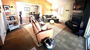 A cozy living room with a sectional sofa, a fireplace, and a dining area with a table and chairs.