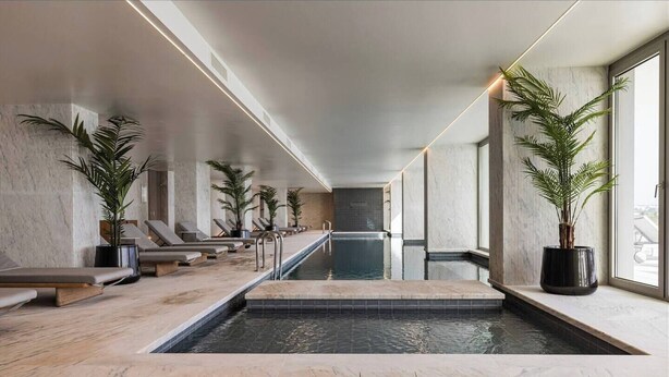 A modern indoor pool area with lounge chairs and potted plants. - Bayline Algarve Apt – Beachfront, Spa, Lagoon View (Armação de Pêra)
