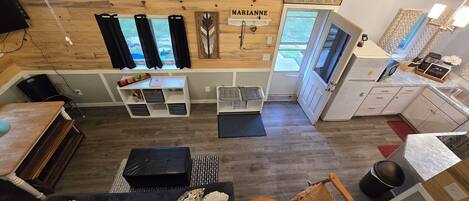 Een compacte, moderne woonruimte met een kitchenette, een eethoek en een zithoek met een bank en stoelen.