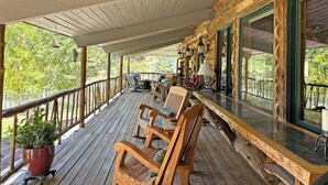A wooden deck with outdoor seating and a glass enclosure.