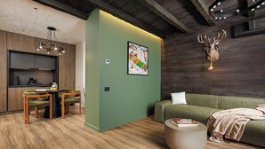 Un salón moderno con una pared verde de acento, techo de madera y una decoración con cabeza de venado.