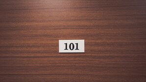 Superficie de madera con una etiqueta blanca que muestra el número 101.