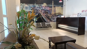 Eine Lobby mit einer Rezeption, einer Sitzecke und einer großflächigen Stadtansicht als Wandmalerei.