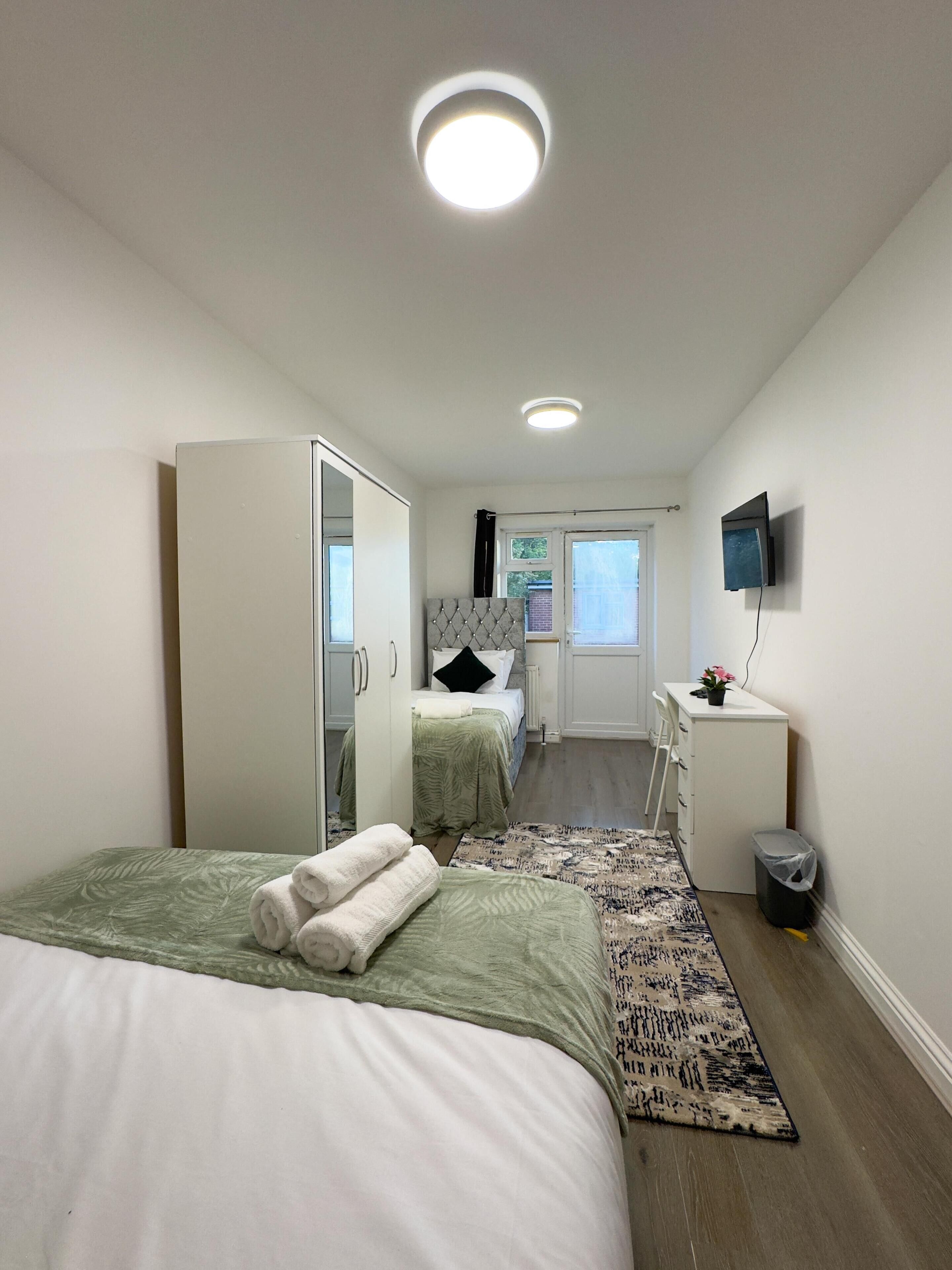 Una habitación de hotel moderna con dos camas, un escritorio, un televisor y un baño.
