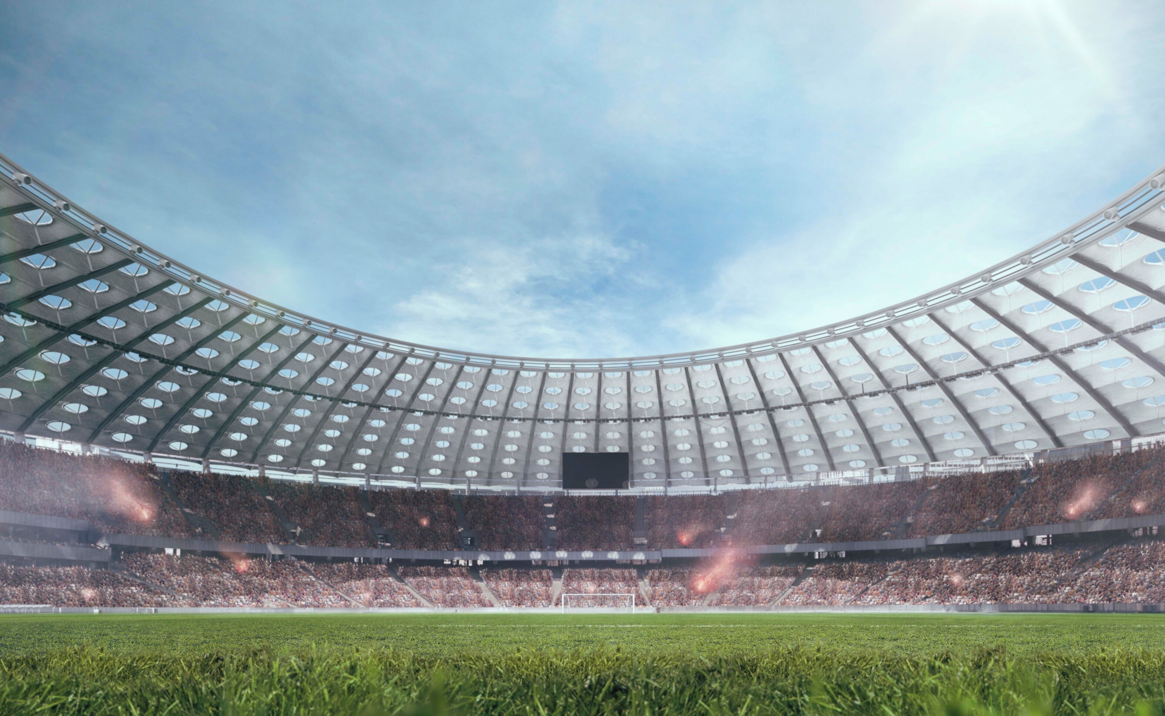 A stadium with a large, curved roof and multiple tiers of seating.