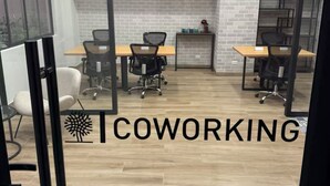 A modern coworking space with wooden flooring, black office chairs, and a brick wall. - Nephi’s Villas Modern 2 Bedroom Apartment with Pool, Gym. Miraflores Location (Miraflores)