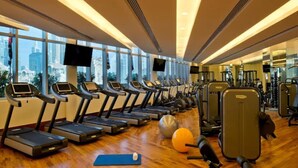 A gym with treadmills, exercise balls, and weights. - Chic 1-BR | Balcony City Views, Mall+Pool+Parking (Dubai)
