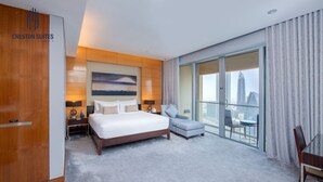 A hotel room with a large bed, a sitting area, a view of the city, and a sliding glass door. - Iconic Burj View Studio | Balcony + Mall & Pool (Dubai)