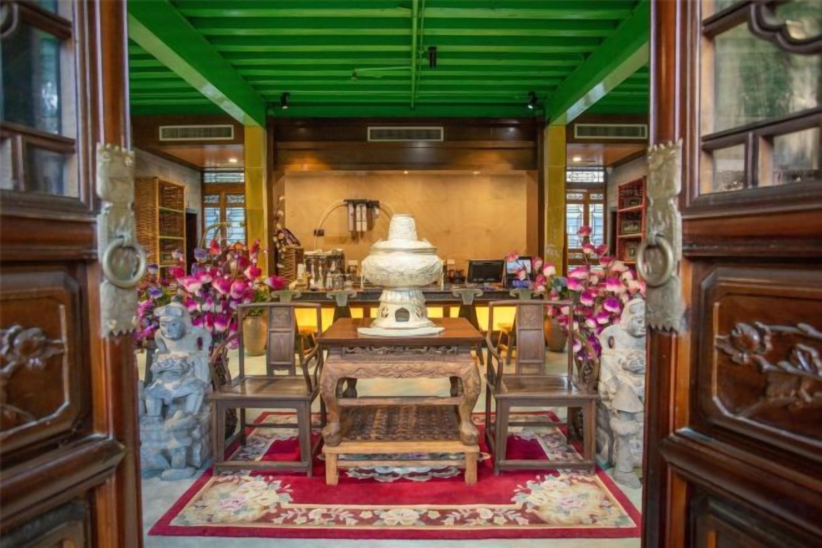 A traditional room with a central table, chairs, and a decorative vase.