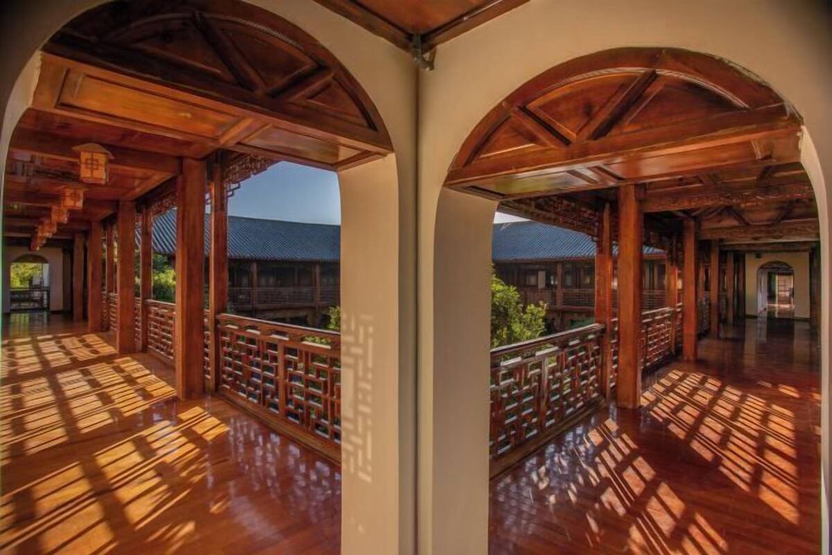 Un interior de madera con techos abovedados y un balcón con barandilla de madera.