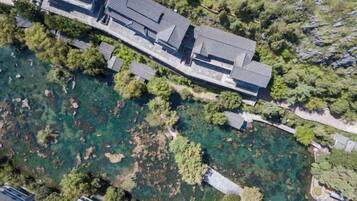 An aerial view of a building with a swimming pool surrounded by trees.