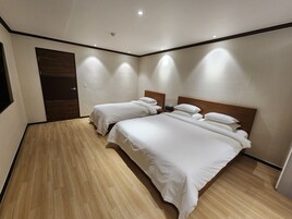 Habitación de hotel con dos camas, piso de madera y diseño moderno.