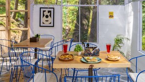 Un comedor con mesa de madera, sillas azules y una lámpara colgante.