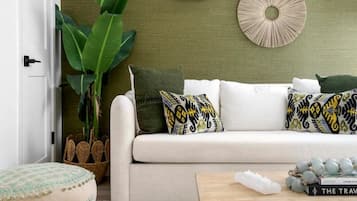 A living room with a sofa, a coffee table, and decorative wall art.