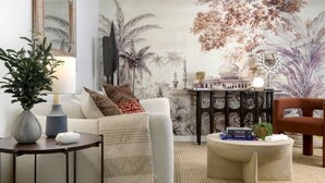 Een woonkamer met een bank, een salontafel, een bijzettafeltje en een wanddecoratie.