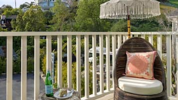A balcony with wicker furniture, a decorative umbrella, and a bag labeled 'SANTA BARBARA'.
