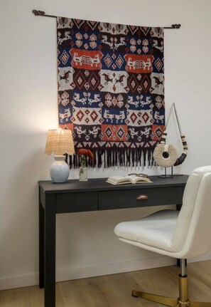 A desk with a lamp, a vase with flowers, and a book. - Bali Home | SB Beaches (Summerland)
