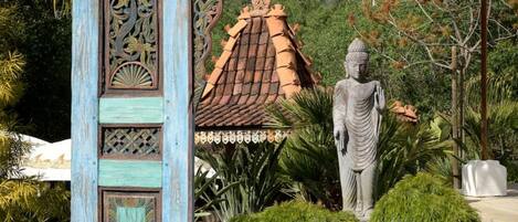 A traditional structure with intricate carvings, a statue, and a tiled roof.