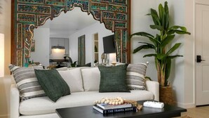 A living room with a white sofa, a coffee table, and a large decorative mirror with an ornate frame. - Group-Friendly | Tranquil Oasis (Summerland)